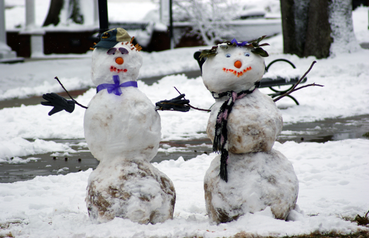 Adorable couple made of snow with contagious smiles. 
